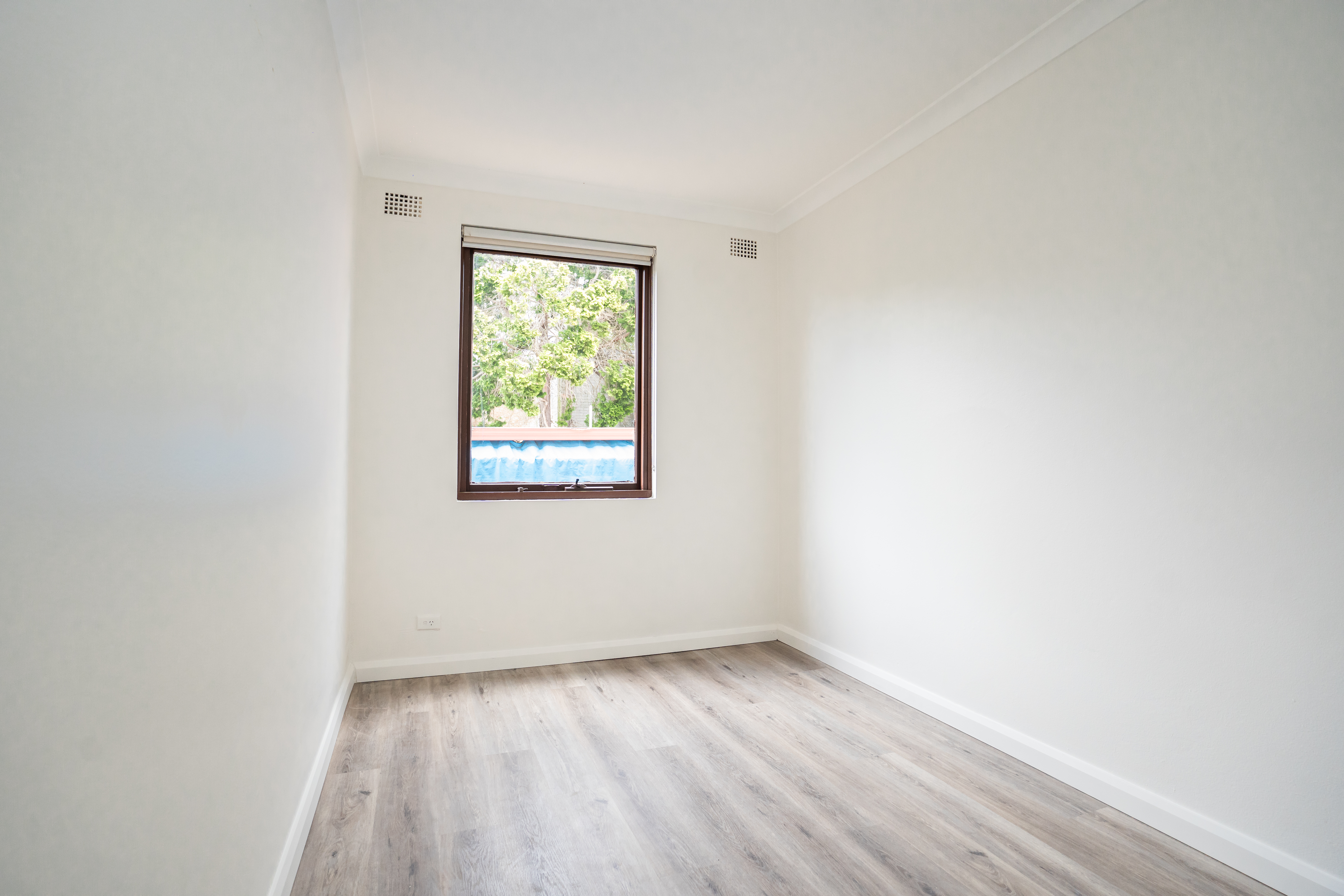 Bedroom renovation — new timber-look flooring with bright window