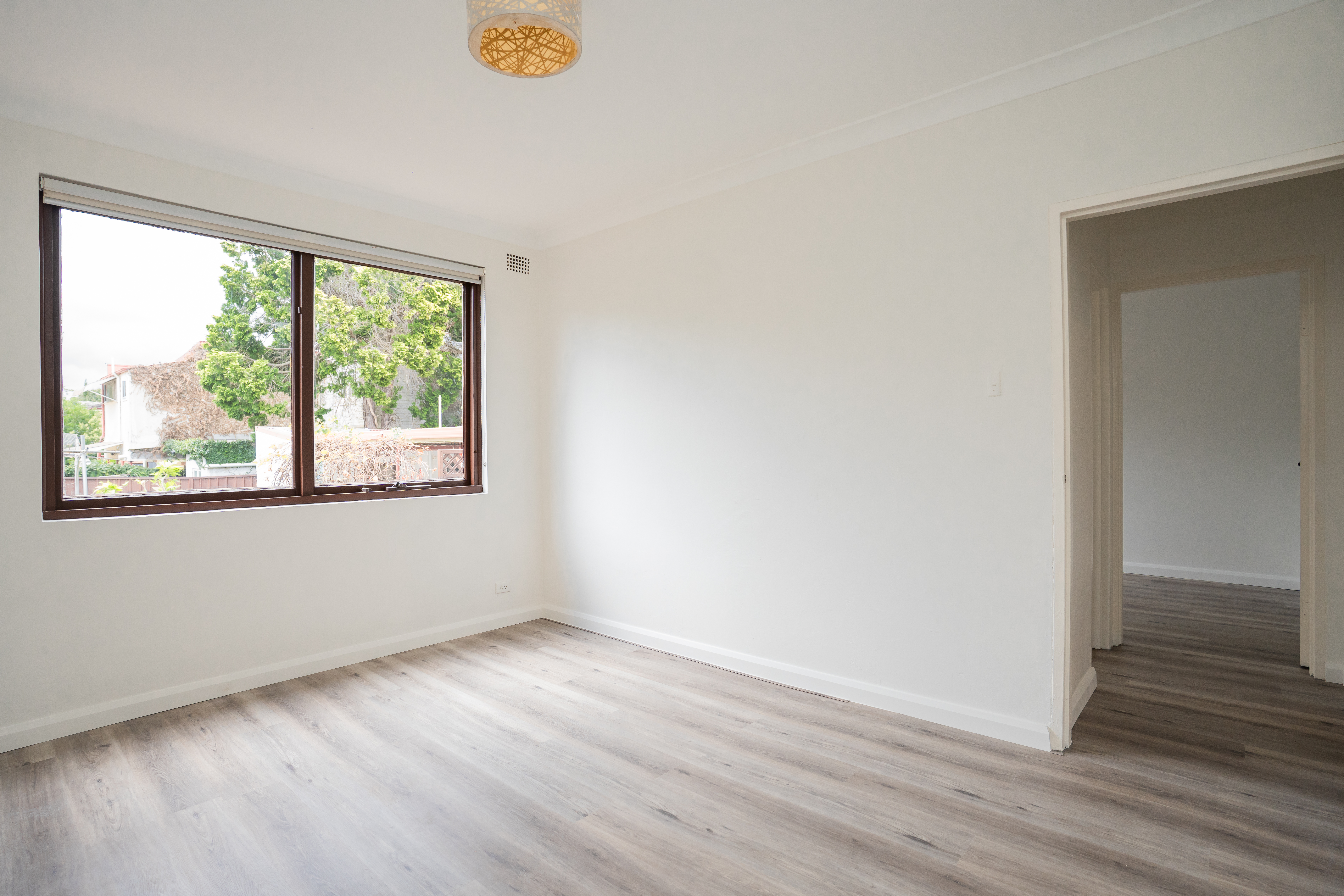 Living room — timber flooring with pendant light and sliding windows