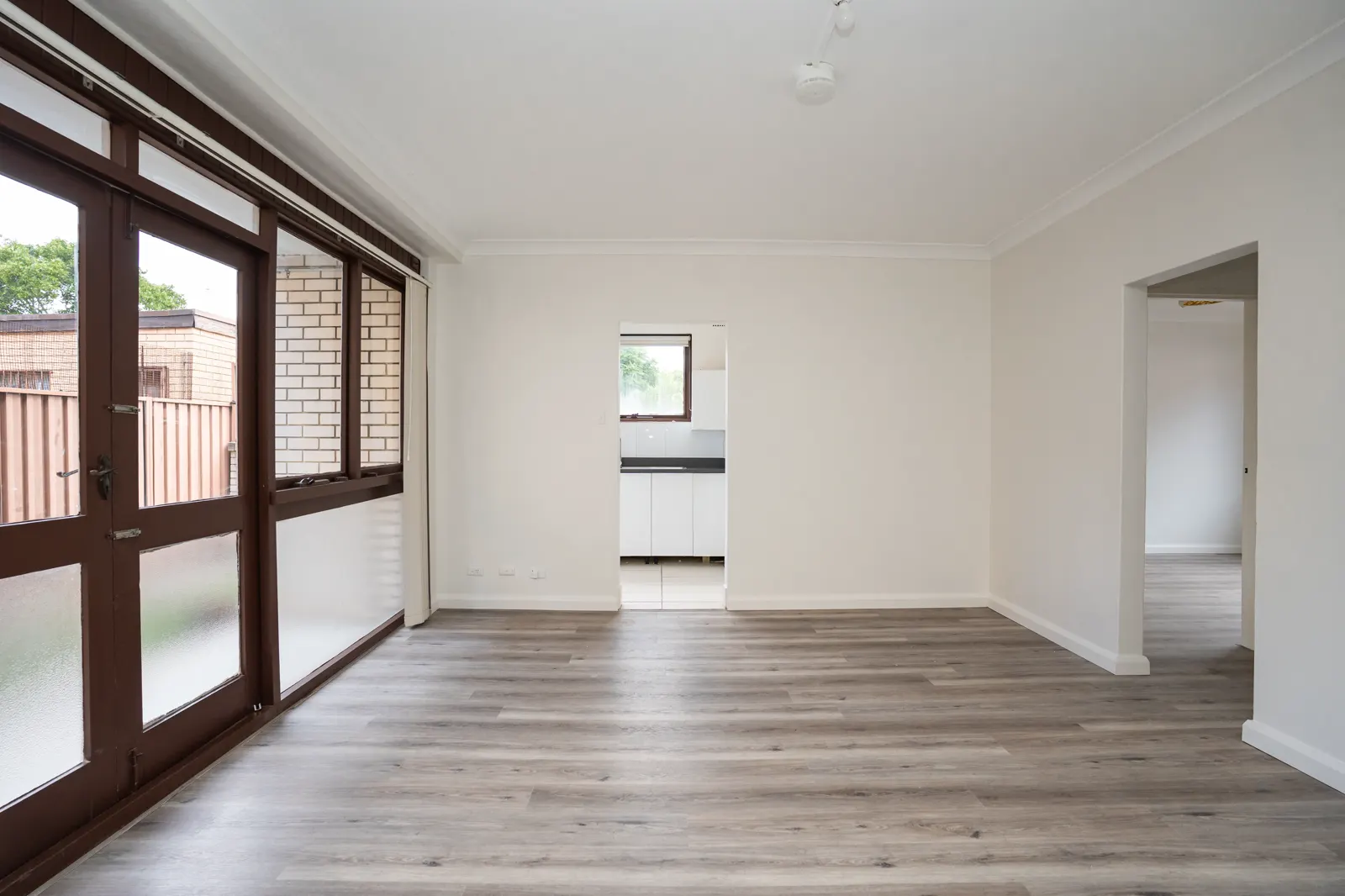 Open-plan living — timber flooring with sliding doors to balcony